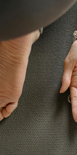 Close-up of hands and feet on a yoga mat, showing stability and balance.